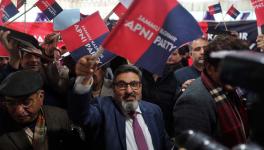 Former PDP leader Altaf Bukhari (center) waves the new party flag after launching Apni Party