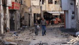 A couple walks in a street in the Jenin refugee camp. Image Courtesy [Ronaldo Schemidt/AFP]