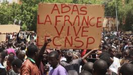 Protesters with sign that reads: Down with France, long live the CNSP (National Council for the Safeguard of the Homeland).