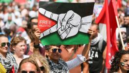 A protester in Brussels, Belgium, holds a placard reading 'Free Palestine' during a demonstration showing solidarity with Palestinians (Photo: Al Jazeera)