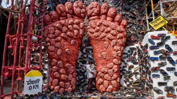 An artist works on a pandal depicting the plight of farmers in the country and their ongoing agitation, ahead of Durga Puja Festival in Kolkata