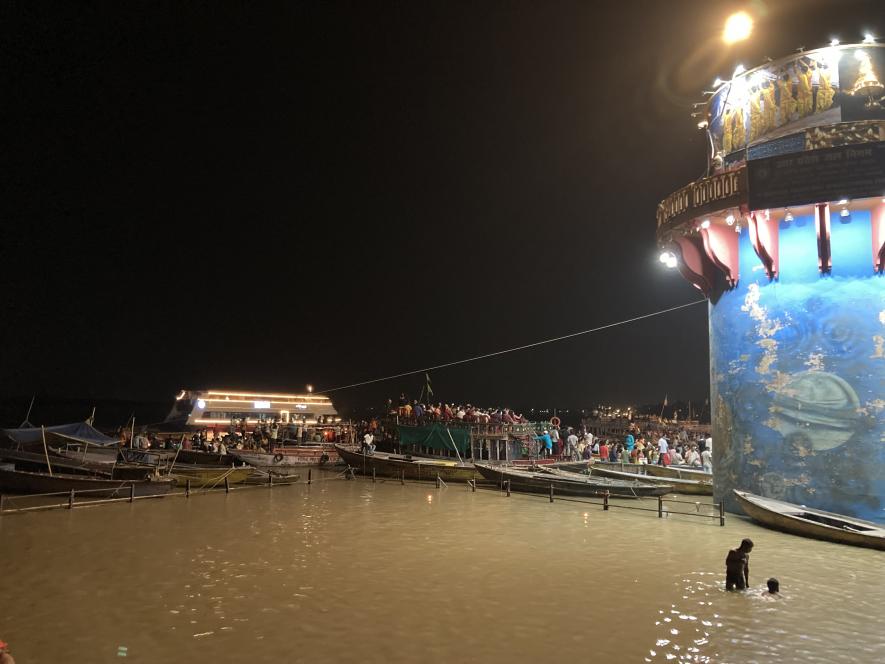 Cruise ship behind navik boats moving across Rajendra Prasad Ghat.