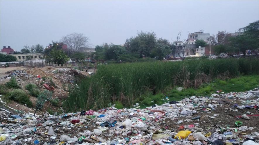 Asola's pond land, now a barren land, where some of the land has been captured by the locals and the rest is full of garbage.