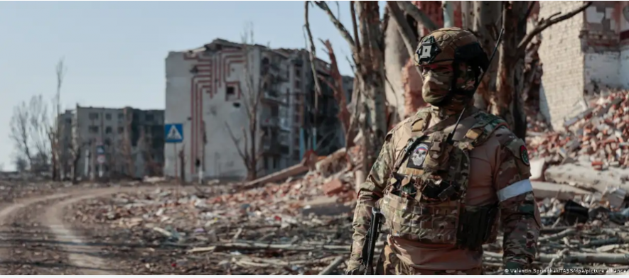 A Wagner Group soldier guards an area outside apartment blocks in the city of Artyomovsk (Bakhmut)