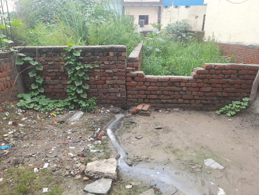 This is what the manual drainage system built by the residents themselves looks like, going into the empty plot.