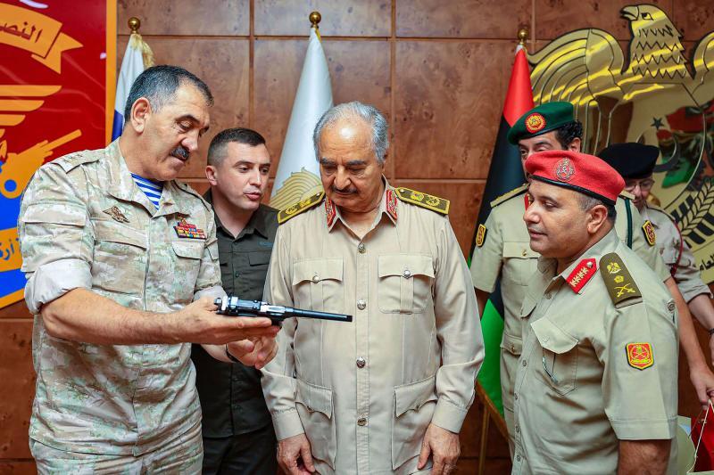 Russia’s Deputy Defence Minister Colonel-General Yunus-bek Yevkurov (L) presents a pistol as gift to Libyan military commander Field Marshal Khalifa Haftar (C), Benghazi, Libya, August 24, 2023