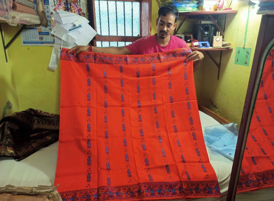 Small trader Raju Pal showing Baluchari sarees in his shop in Vaishnabpara.